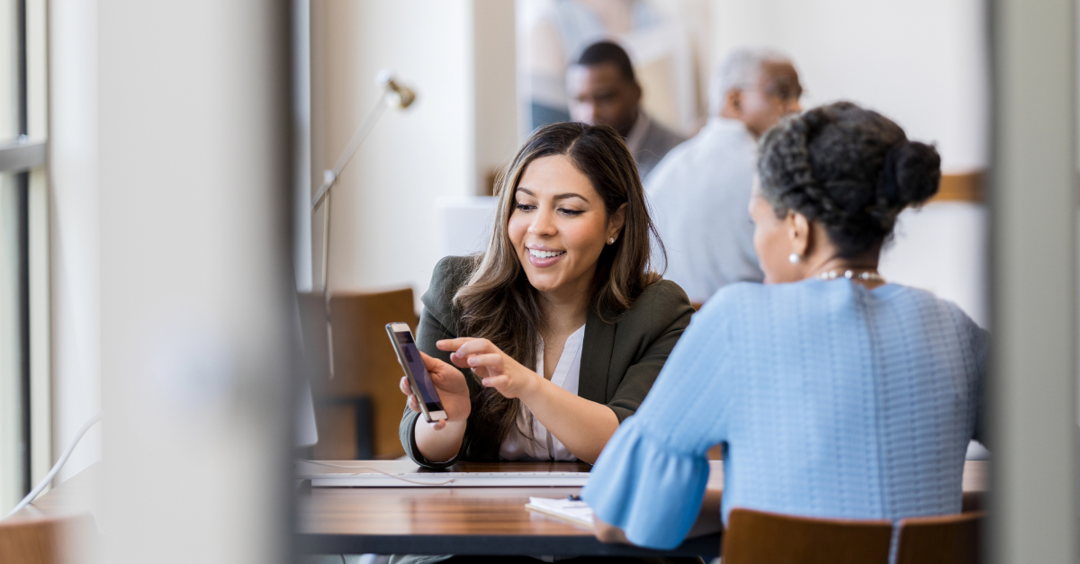 Woman pointing at phone in credit union