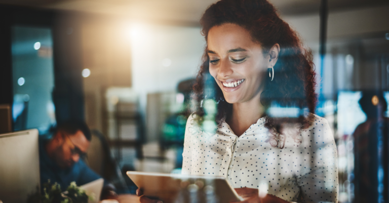 Woman looking at tablet smiling